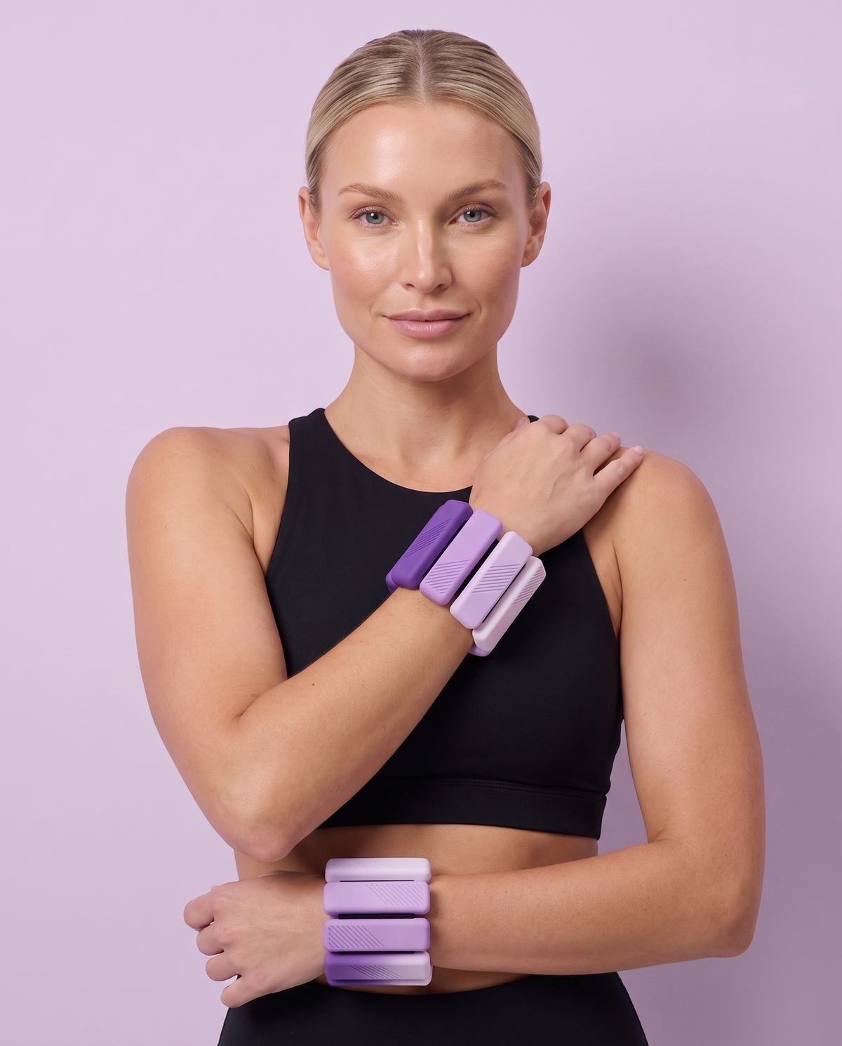 Woman in a black sports bra wearing Lilac Ombre OmbreWeight wrist weights on both wrists